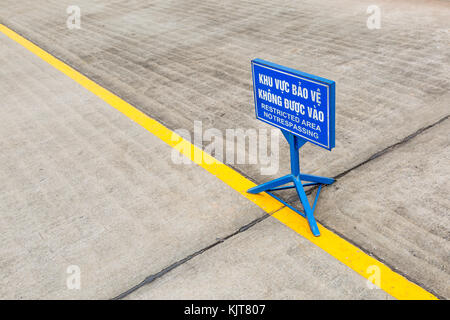 Segno blu per area riservata (NO) sconfinamenti in vietnamita e inglese dietro una linea gialla nella parte anteriore del mausoleo di Ho chi minh ad Hanoi, Vietnam Foto Stock