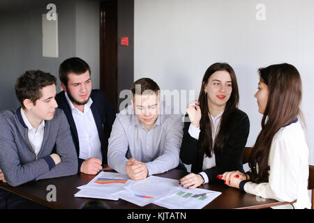 Tre uomini intelligenti e due ragazza carina programmatori costituiscono il concetto di Foto Stock