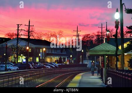 Union Pacific Railroad le vie al Glen Ellyn, Illinois station come crepuscolo scende sulla scena. Glen Ellyn, Illinois, Stati Uniti d'America. Foto Stock