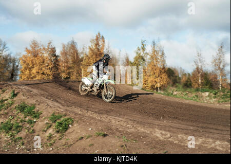 Motocross Enduro rider in azione accelerando la moto dopo l'angolo su sporco della pista. extreme off-road race. hard enduro moto. autunno Foto Stock