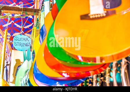 Molti classici in legno colorato chitarre appeso alla parete del negozio showroom, la configurazione di sfondo in Istanbul grand bazaar Foto Stock