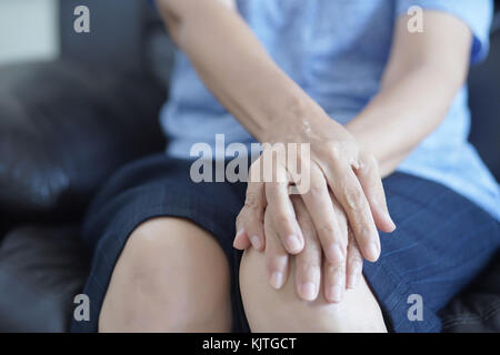 Artrite persona vecchia e donna anziana donna che soffre di dolore a casa Foto Stock