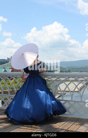 Donna sul ponte che si affaccia su un fiume. Foto Stock