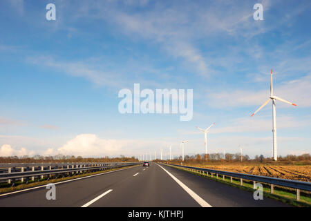 Mulini a vento lungo l autostrada a31 nei pressi della città di leer, la Germania in una giornata di sole. vista dal driver della prospettiva. Foto Stock