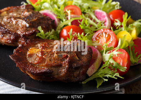 Agnello arrosto bistecca e verdura fresca insalata di close-up su una piastra orizzontale. Foto Stock