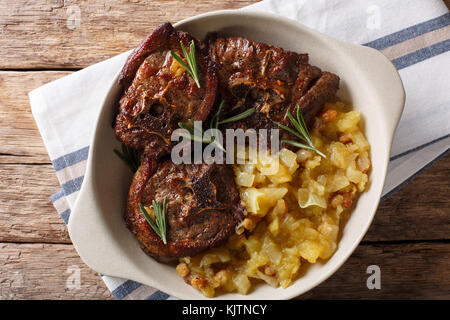 Agnello arrosto bistecca e mostarda di mele speziate close-up in una ciotola sul tavolo. parte superiore orizzontale vista da sopra Foto Stock