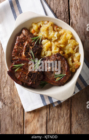 Il cibo indiano: bistecca di agnello e mostarda di mele speziate close-up in una ciotola sul tavolo. verticale in alto vista da sopra Foto Stock