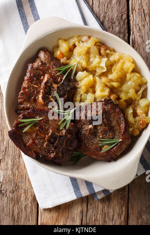 Agnello arrosto bistecca e mostarda di mele speziate close-up in una ciotola sul tavolo. verticale in alto vista da sopra Foto Stock