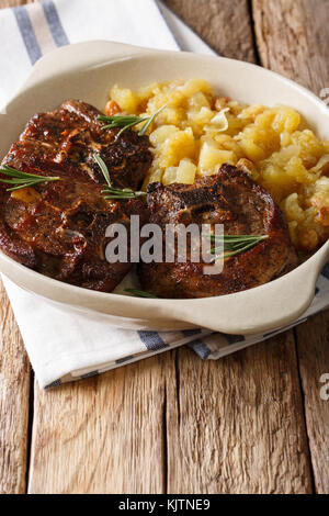 Agnello arrosto bistecca e mostarda di mele speziate close-up in una ciotola sul piano verticale. Foto Stock