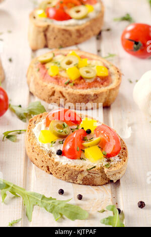 Mini sandwich chiamato bruschette con formaggio,pepe,cipolla e pomodoro.Il fuoco selettivo sulla parte anteriore della bruschetta Foto Stock