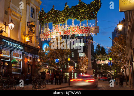 London, Regno Unito - 24 novembre 2017: le luci di Natale su Seven Dials; luci stagionali vengono visualizzati sopra la zona è molto trafficata del centro di Londra. Foto Stock