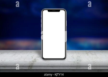 Moderne smart phone con schermo x su bianco tavolo in legno isolati a schermata vuota per mockup. paesaggio cittadino in background. Foto Stock