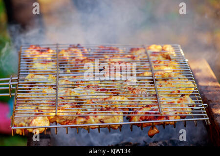 Grigliata di coscia di pollo sulla griglia fiammeggianti il pollo sul grill Foto Stock