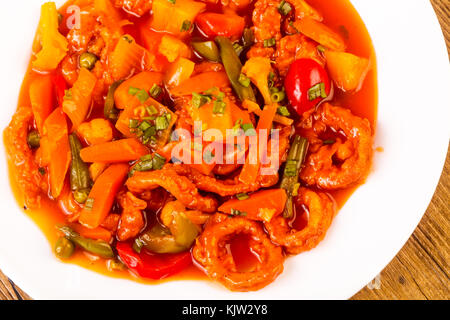 Anelli di totano in salsa agrodolce con spezie e verdure Foto Stock