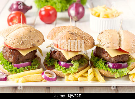 Tre american big cheeseburger e patatine fritte sulla piastra Foto Stock