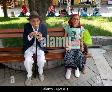 Due persone sedersi sulla panchina del parco Foto Stock