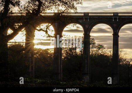 Bassa autunnale di sole che splende attraverso gli archi del Ouse Valley il viadotto in West Sussex Foto Stock