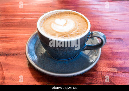 Tazza di caffè servito in blu tazza di ceramica sul tavolo di legno Foto Stock