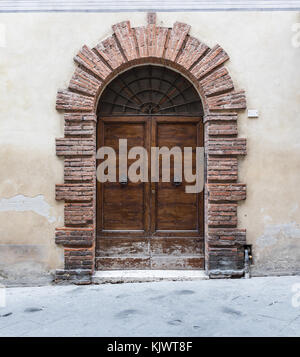 Le porte in legno massiccio tipico del sud dell'Italia. Porta di legno insieme in un vecchio muro di pietra. Vecchie porte vintage. Vecchia porta di legno in una casa di pietra italiano Foto Stock