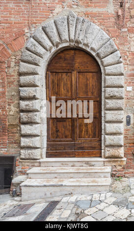 Le porte in legno massiccio tipico del sud dell'Italia. porta di legno insieme in un vecchio muro di pietra. vecchie porte vintage. vecchia porta di legno in una casa di pietra italiano Foto Stock