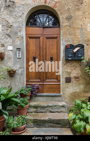 Le porte in legno massiccio tipico del sud dell'Italia. porta di legno insieme in un vecchio muro di pietra. vecchie porte vintage. Foto Stock