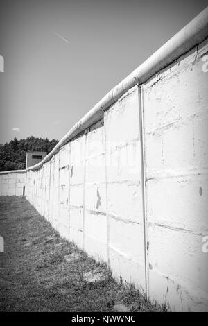 Nel 1989 la rivoluzione pacifica ha strappato il muro. Prima del 9 novembre 1989 la cortina di ferro era una zona di morte in Germania: 245 persone, che volevano fuggire dalla Germania orientale, furono uccise nel tentativo di attraversare questo confine disumano. MoedLareuth, un piccolo villaggio, è stato seperato da questo muro in una parte occidentale e orientale come a Berlino. Per questo motivo si chiamava piccola Berlino. La foto è scattata nel Museo tedesco-tedesco di MoedLareuth. Foto Stock