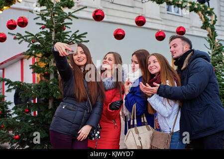 Cinque giovani rendendo le foto al mercatino di natale Foto Stock