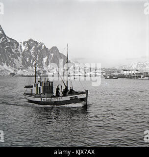 Una fotografia in bianco e nero della collezione Kanstadsamlingen, che mostra due barche da pesca che navigano attraverso un fiordo con montagne innevate sullo sfondo. Foto Stock