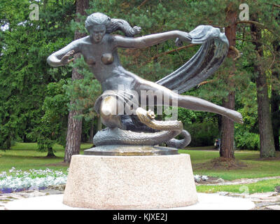 PALANGA, LITUANIA - 12 AGOSTO 2009: Statua di bronzo di donna e serpente situata nel parco cittadino. Foto Stock