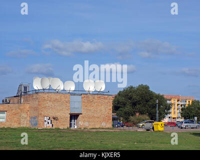 LIEPAJA, LETTONIA - 14 SETTEMBRE 2015: Televisione via cavo e stazione Internet con antenne satellitari sul tetto si trova in un piccolo edificio in mattoni Foto Stock