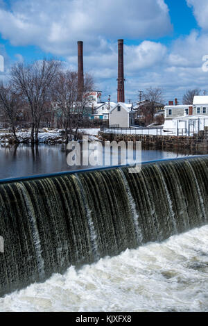 Cascate dalla Grande diga di pietra con pile di fumo sullo sfondo nell'ex città tessile di Lawrence, Massachusetts. Foto Stock