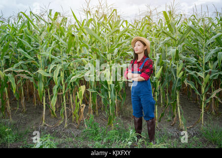 Felice agricoltore che pongono nel campo di grano Foto Stock