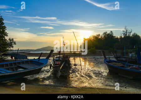 Coda lunga barca da pesca parcheggiato presso la spiaggia e il mare è inferiore. Lo sfondo è il tramonto e nuvoloso cielo blu. Foto Stock