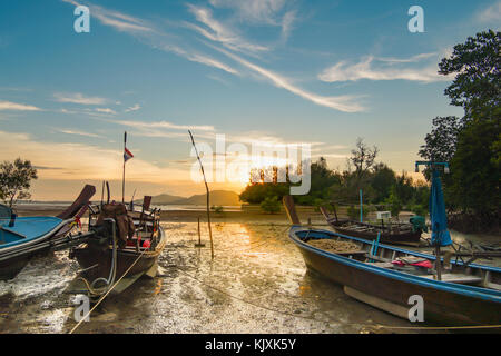 Coda lunga barca da pesca parcheggiato presso la spiaggia e il mare è inferiore. Lo sfondo è il tramonto e nuvoloso cielo blu. Foto Stock