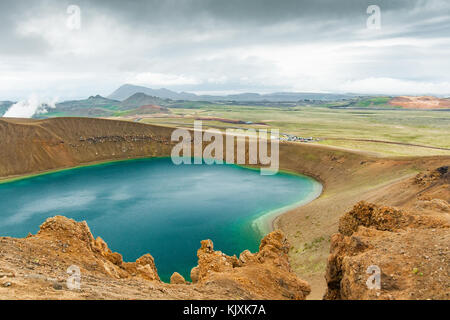Acque turchesi circondato da orange rock dal cratere di Viti Lago del vulcano Krafla area in Islanda Foto Stock