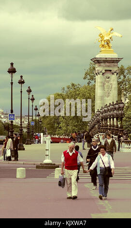 Turisti di passaggio il Pont Alexandre III historique ponte che attraversa il fiume Senna a Parigi decorata con bellissimi lampadari, putti, ninfe statue Foto Stock