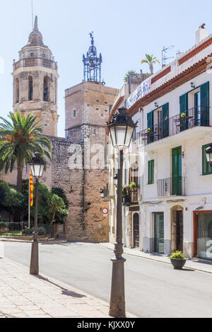 Lampade in una strada a Sitges, Spagna con la Parròquia de Sant Bartomeu mi Santa Tecla nel backgrpound Foto Stock
