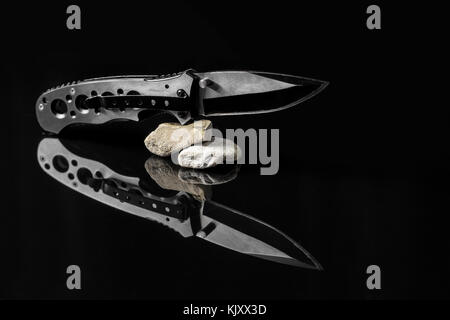 Un piccolo coltello di caccia pieghevole isolato su sfondo bianco. Foto  scattata sotto la luce artificiale morbida Foto stock - Alamy