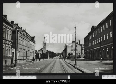 Questa fotografia cattura l'affollato incrocio di Buran, situato a Innherredsveien e Mellomveien a Trondheim, Norvegia, con la Chiesa di Lade visibile sullo sfondo. L'immagine riflette il paesaggio urbano e i sistemi di trasporto dell'area. Foto Stock