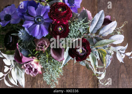 Design floreale, decorazioni per matrimoni, amore concetto. vista dall'alto di adorabili e bouquet di fiori diversi, ci sono delicate rose rosa, lilla anemoni e Castani Scuri roselline Foto Stock