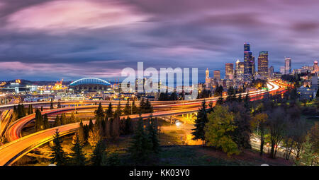 Seattle città al crepuscolo con grattacieli, avvolgimento autostrade dei parchi e arene sportive sotto un cielo drammatico. Foto Stock