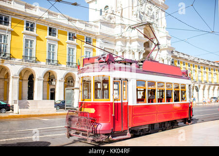 Il vecchio tram turistico sulla piazza centrale con arco di Augusta sullo sfondo a Lisbona, Portogallo Foto Stock