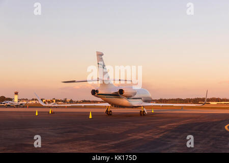 Moderni jet parcheggiato sulla pista nella giornata di sole, un tramonto meraviglioso. Foto Stock