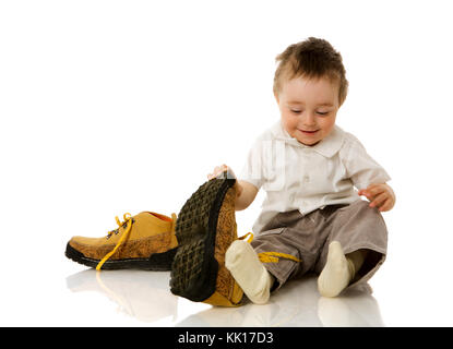 Un anno ragazzo cercando padre isolato shoos su bianco Foto Stock