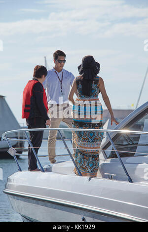 Immagine dello stile di vita del personale e la gente di vendite accogliente una femmina di cliente a bordo di una barca show. Foto Stock