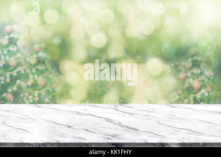 Vuoto in marmo bianco del tavolo con abstract sfocatura verde albero di natale e la caduta di neve con sfondo bokeh,luce sfondo vacanze,mock up banner per dis Foto Stock