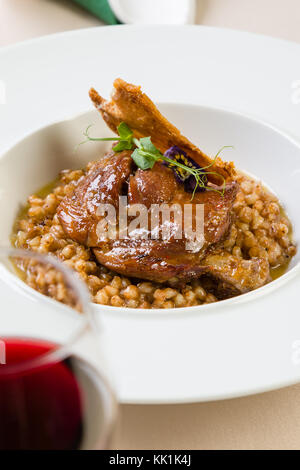 Gourmet di carne fresca di anatra con orzo nella piastra bianca Foto Stock