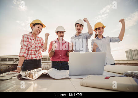 Felice costruzione professionale di ingegneri che lavorano in azione di saluti dopo aver completato il progetto con colleghi aziendale il lavoro di squadra, industriale engi Foto Stock