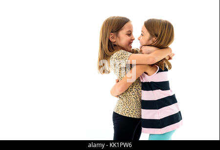 Gemello ragazze stanno cercando in ogni altro e sorridente. concetto di famiglia e sisterly amore. profilo vista laterale delle sorelle giocando, avvolgente, smilin Foto Stock