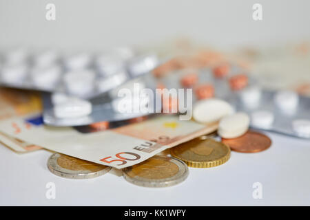 Medicina farmaci pillole in strisce e le banconote e le monete in euro Foto Stock